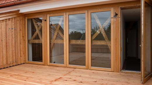 Bodentiefe Holz-Fenster auf Terrasse